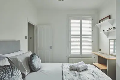 a bedroom with a bed with two towels on it at Hollie Cottage in Lytham St Annes