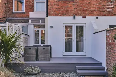 a white front door of a brick building at Hollie Cottage in Lytham St Annes