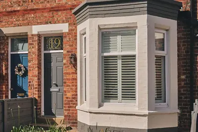 a brick house with a window and a door at Hollie Cottage in Lytham St Annes