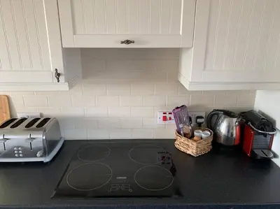 a kitchen with a counter top with a stove top oven at The Bungalow in Preston