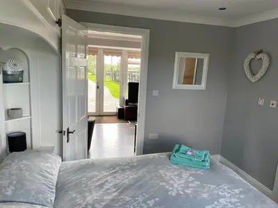 a bedroom with a bed and a door to a living room at The Bungalow in Preston