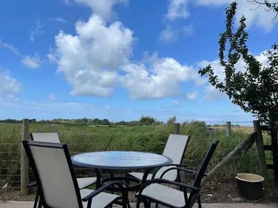 a table and chairs with a view of a field at The Bungalow in Preston