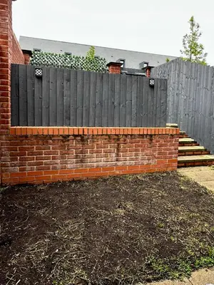 a brick retaining wall with a wooden fence at Relax Inn in Liverpool
