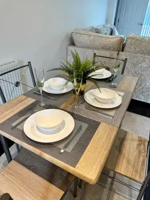 a wooden table with plates and wine glasses on it at Relax Inn in Liverpool