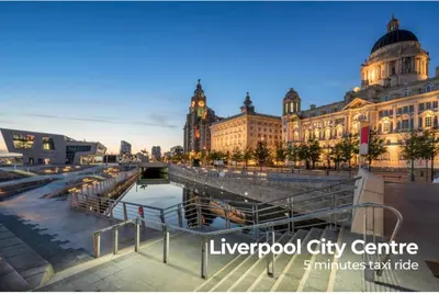 a large building with a river in front of it at Relax Inn in Liverpool