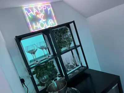 a happy hour sign in a room with wine glasses at The White House New York Suites in Blackpool