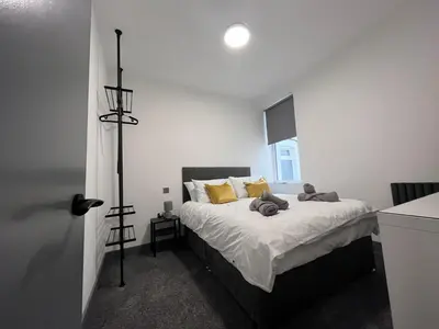 a bedroom with a large bed with yellow pillows at The White House New York Suites in Blackpool