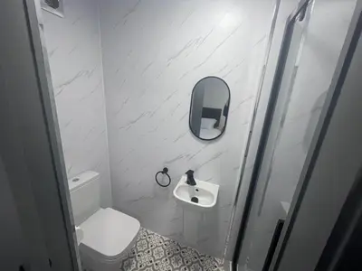 a small bathroom with a toilet and a sink at The White House New York Suites in Blackpool