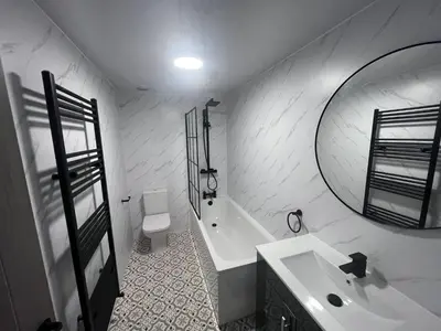 a bathroom with a sink and a tub and a mirror at The White House Vegas Suites in Blackpool