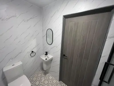 a bathroom with a toilet and a sink and a door at The White House Vegas Suites in Blackpool