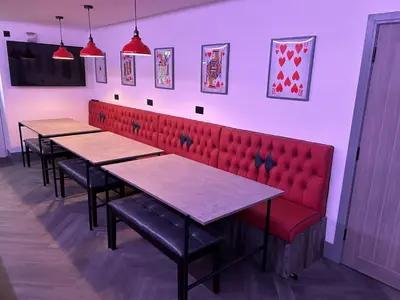 a row of tables in a restaurant with red booths at The White House Vegas Suites in Blackpool