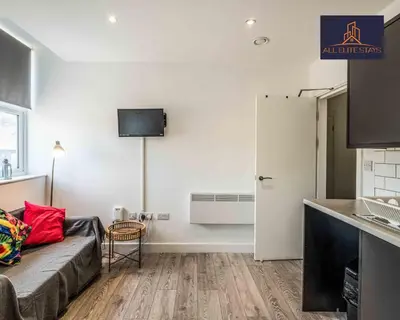 a living room with a couch and a kitchen at Swan House Apartment 4 - 1 Bed Apartment - Sleeps up to 4 - Free Parking - Liverpool - close to city centre - By ALL ELITE STAYS in Liverpool