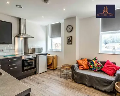a living room with a couch and a kitchen at Swan House Apartment 4 - 1 Bed Apartment - Sleeps up to 4 - Free Parking - Liverpool - close to city centre - By ALL ELITE STAYS in Liverpool