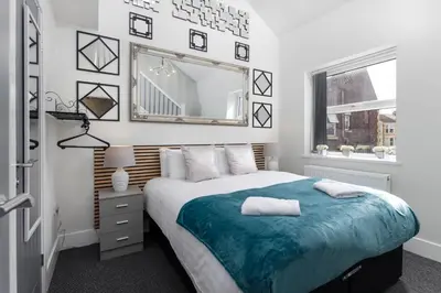 a bedroom with a large bed and a mirror at Teck House - Air Host & Stay - 5 mins to Hospital in Liverpool