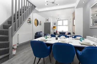 a dining room with a table and blue chairs at Teck House - Air Host & Stay - 5 mins to Hospital in Liverpool