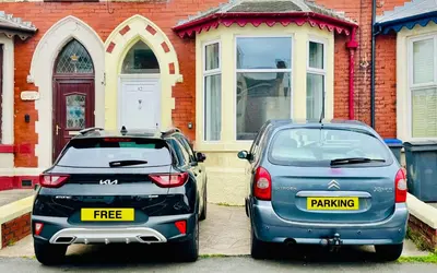 two cars parked in front of a house at Magenta Melodies, 5 Bedroom House in Blackpool