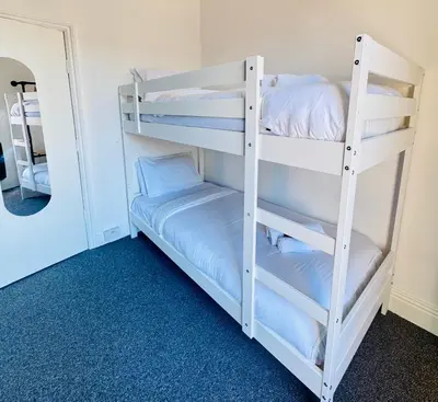 a bunk bed room with two bunk beds and a mirror at Magenta Melodies, 5 Bedroom House in Blackpool