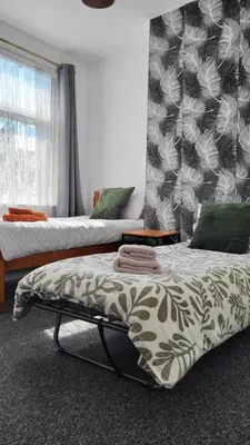 a bedroom with two beds and a window at House 36 in Liverpool