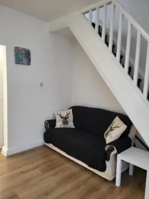 a living room with a couch under the stairs at House 36 in Liverpool