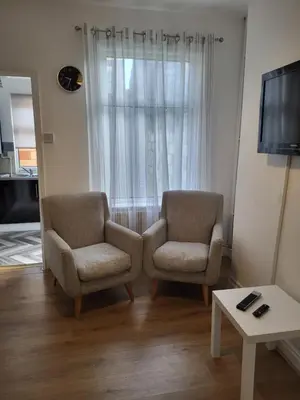 a living room with two chairs and a tv at House 36 in Liverpool
