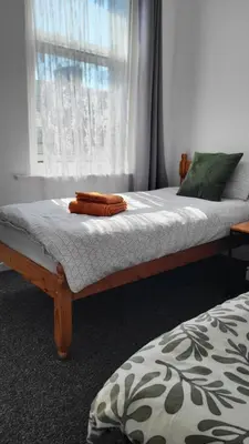 two beds in a room with a window at House 36 in Liverpool
