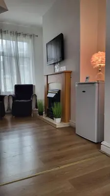 a living room with a fireplace and a flat screen tv at House 36 in Liverpool