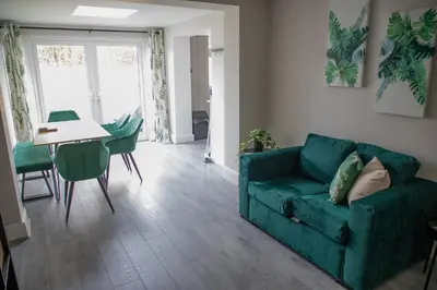 a living room with a green couch and a table at Wave Stays - Ground Floor Apartment - Outside Seating Area in Cleveleys