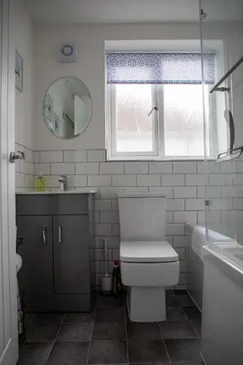 a bathroom with a toilet and a sink and a mirror at Wave Stays - First Floor Apartment - Heart of Cleveleys in Cleveleys