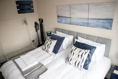 a bedroom with a white bed with two pillows at Wave Stays - First Floor Apartment - Heart of Cleveleys in Cleveleys