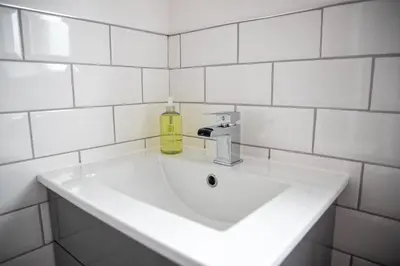 a white bathroom sink with a yellow bottle on it at Wave Stays - First Floor Apartment - Heart of Cleveleys in Cleveleys