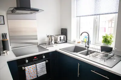 a kitchen with a sink and a stove top oven at Wave Stays - First Floor Apartment - Heart of Cleveleys in Cleveleys