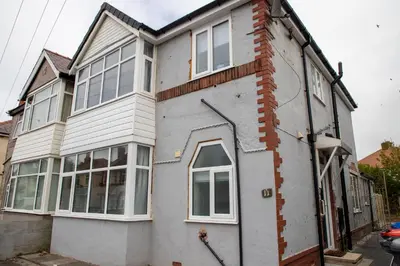 a white house with a lot of windows at Wave Stays - First Floor Apartment - Heart of Cleveleys in Cleveleys