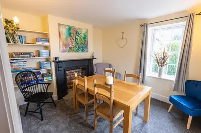 a dining room with a table and a fireplace at Entire cottage & private garden in Scorton in Scorton