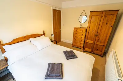 a bedroom with a white bed with two towels on it at Entire cottage & private garden in Scorton in Scorton