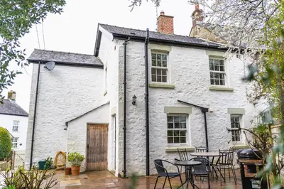 a white cottage with tables and chairs in front of it at Entire cottage & private garden in Scorton in Scorton