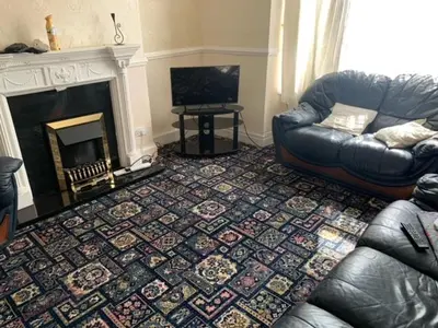 a living room with a couch and a fireplace at Abbey Road in Liverpool