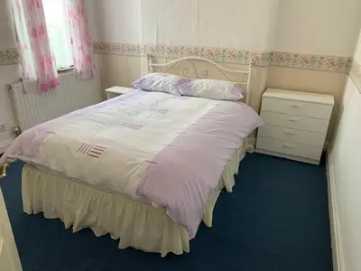 a bedroom with a large bed and a night stand at Abbey Road in Liverpool