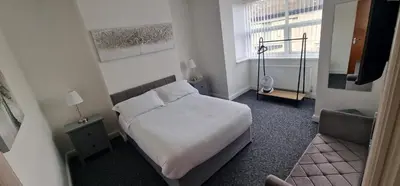 a small bedroom with a bed and a window at LFC Anfield Guest House in Liverpool