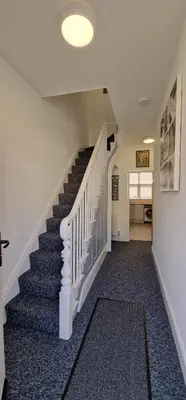 a hallway with a staircase with blue carpet at LFC Anfield Guest House in Liverpool