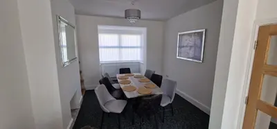 a dining room with a wooden table and chairs at LFC Anfield Guest House in Liverpool