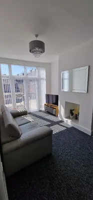 a living room with a couch and a fireplace at LFC Anfield Guest House in Liverpool