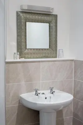 a bathroom with a sink and a mirror at The Swan Hotel in Clitheroe