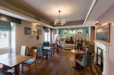 a restaurant with tables and chairs and a fireplace at The Swan Hotel in Clitheroe