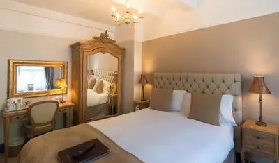 a bedroom with a large white bed and a mirror at The Swan Hotel in Clitheroe