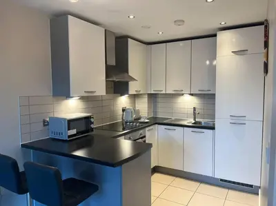 a kitchen with white cabinets and a counter with a microwave at MC Apartment - Central 