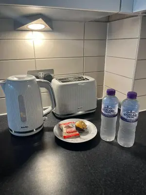 a counter with a toaster and a plate of food and water at MC Apartment - Central 