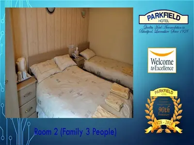 two twin beds in a room with a welcome sign at Parkfield Hotel in Blackpool