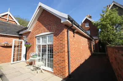 a brick building with a patio with a table and chairs at The Bungalow and Studio Apartments in Lytham St Annes