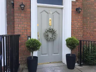 a front door of a house with two potted plants at The Bungalow and Studio Apartments in Lytham St Annes