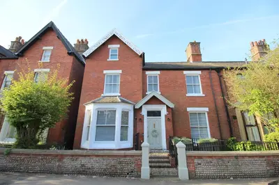 a red brick house with a white door at The Bungalow and Studio Apartments in Lytham St Annes